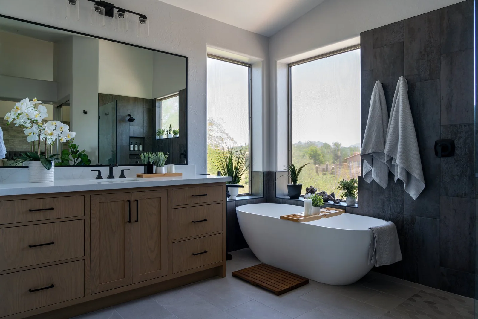Freestanding soaking tub with walk-in shower reflected in vanity mirror, Phoenix bathroom remodel