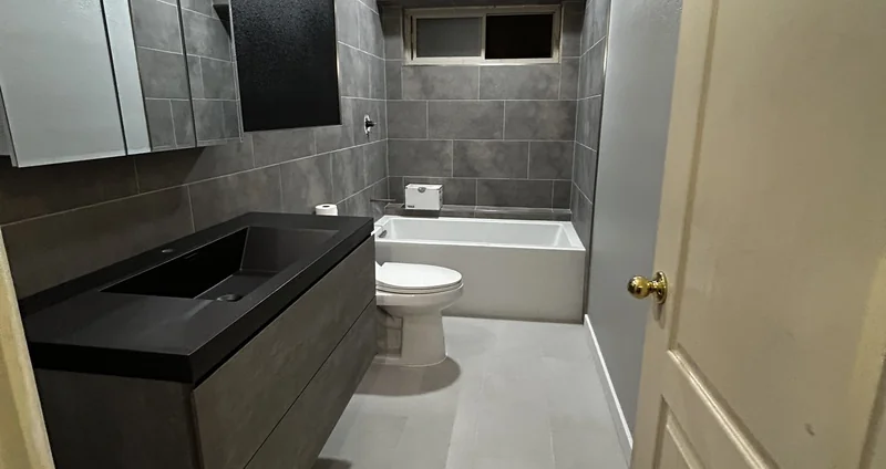 Guest bathroom remodel in Goodyear, AZ with dark vanity and tiled tub surround