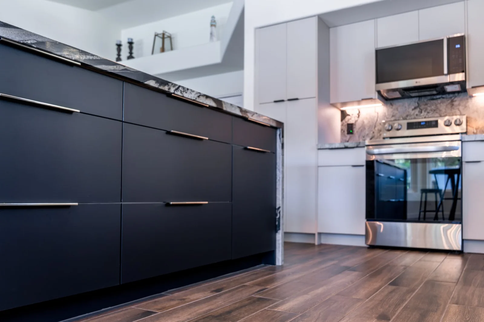 Custom navy island cabinetry and wood-look flooring in a finished Phoenix kitchen remodel