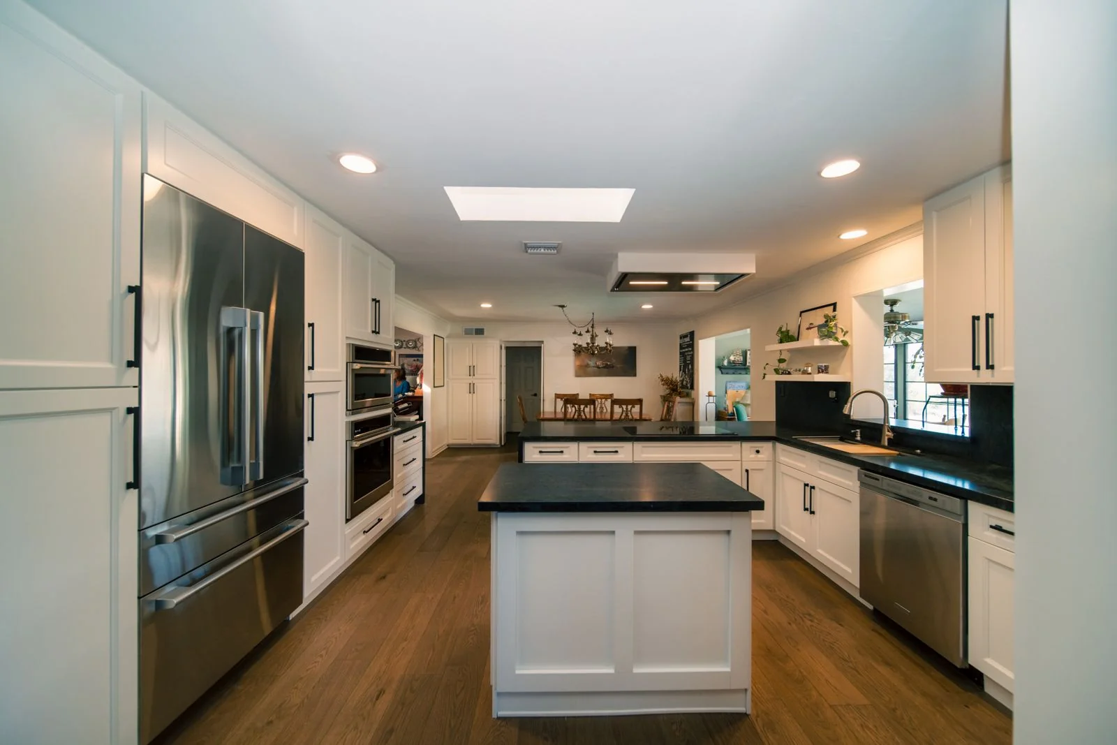 Remodeled kitchen in Scottsdale, AZ with a white island, white shaker cabinets and hardwood floors