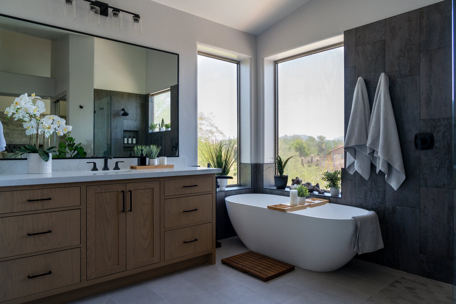 Freestanding soaking tub with walk-in shower reflected in vanity mirror, Phoenix bathroom remodel