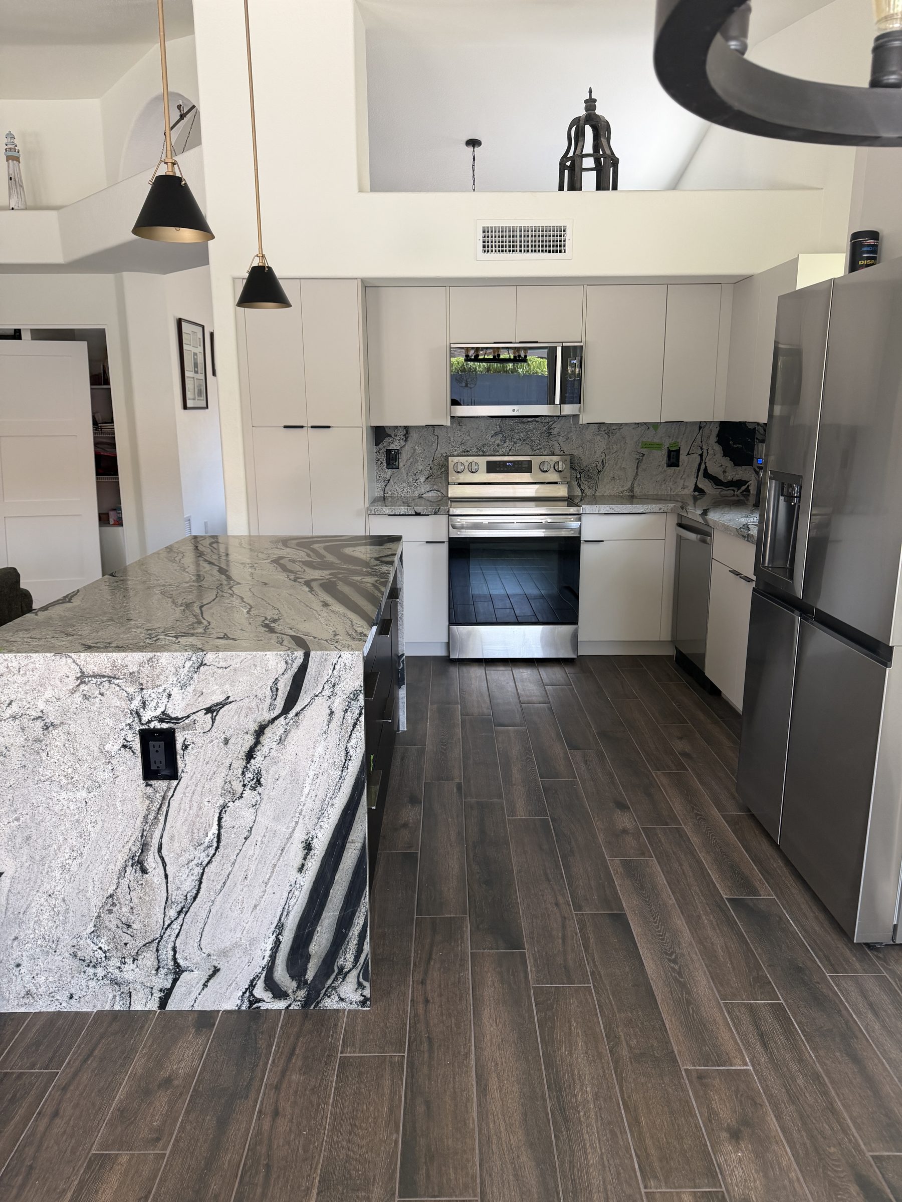 Finished Phoenix kitchen remodel with waterfall quartzite island, custom cabinetry and integrated appliances