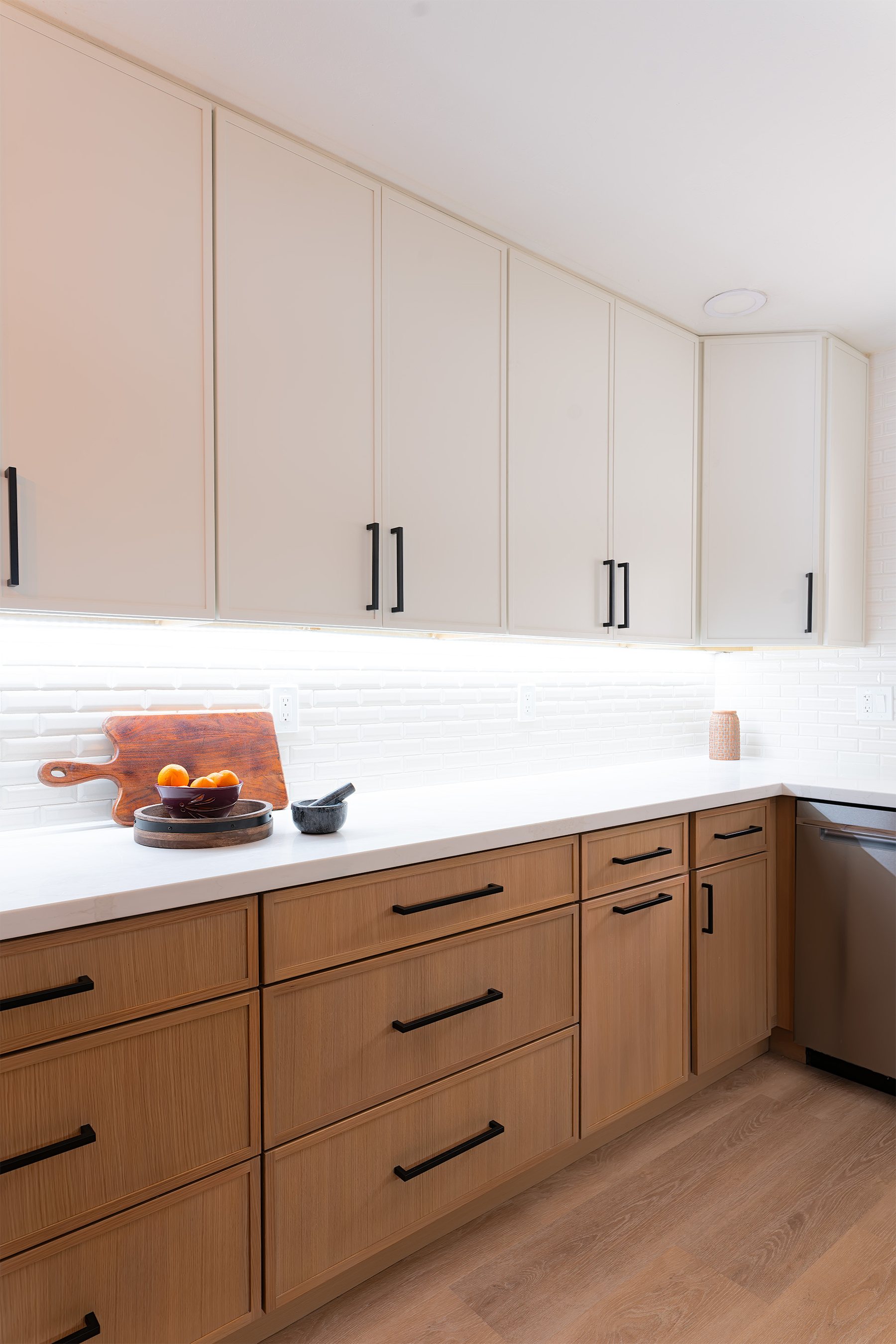 Two-tone custom cabinetry with black bar pulls in a Phoenix kitchen remodel